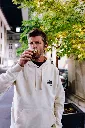 Homme sceptique buvant un cola sous les lumières.webp